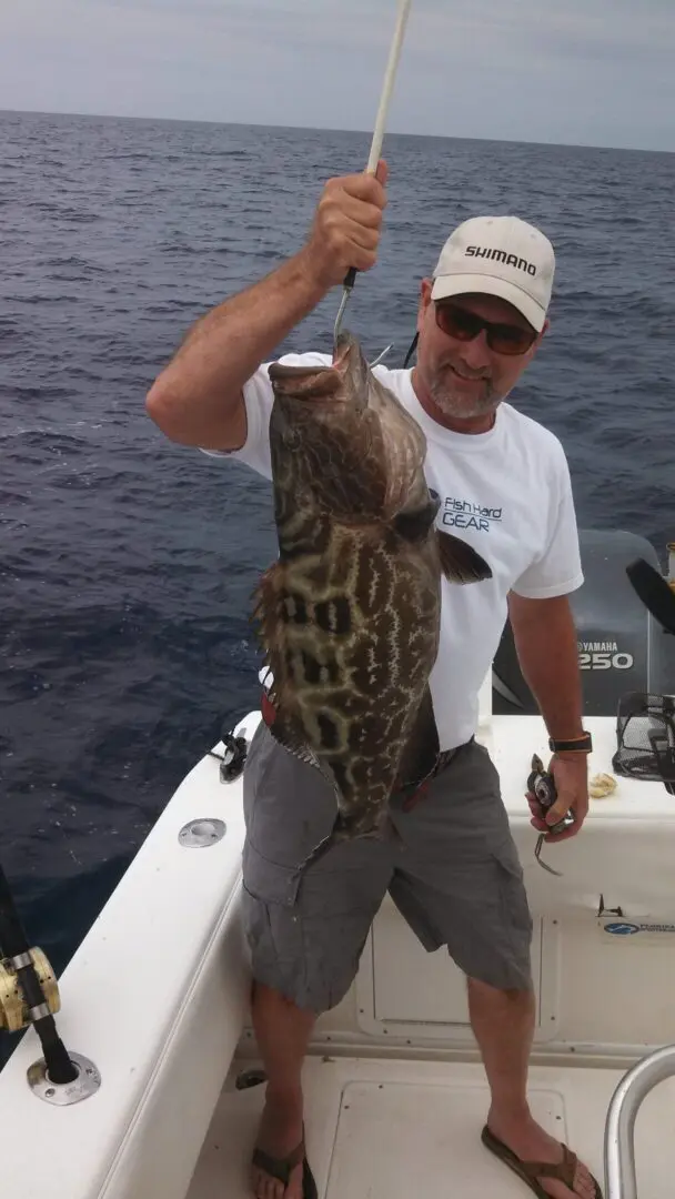 Fisherman proudly holding a large fish.