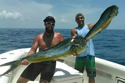 Men proudly displaying their catch at sea